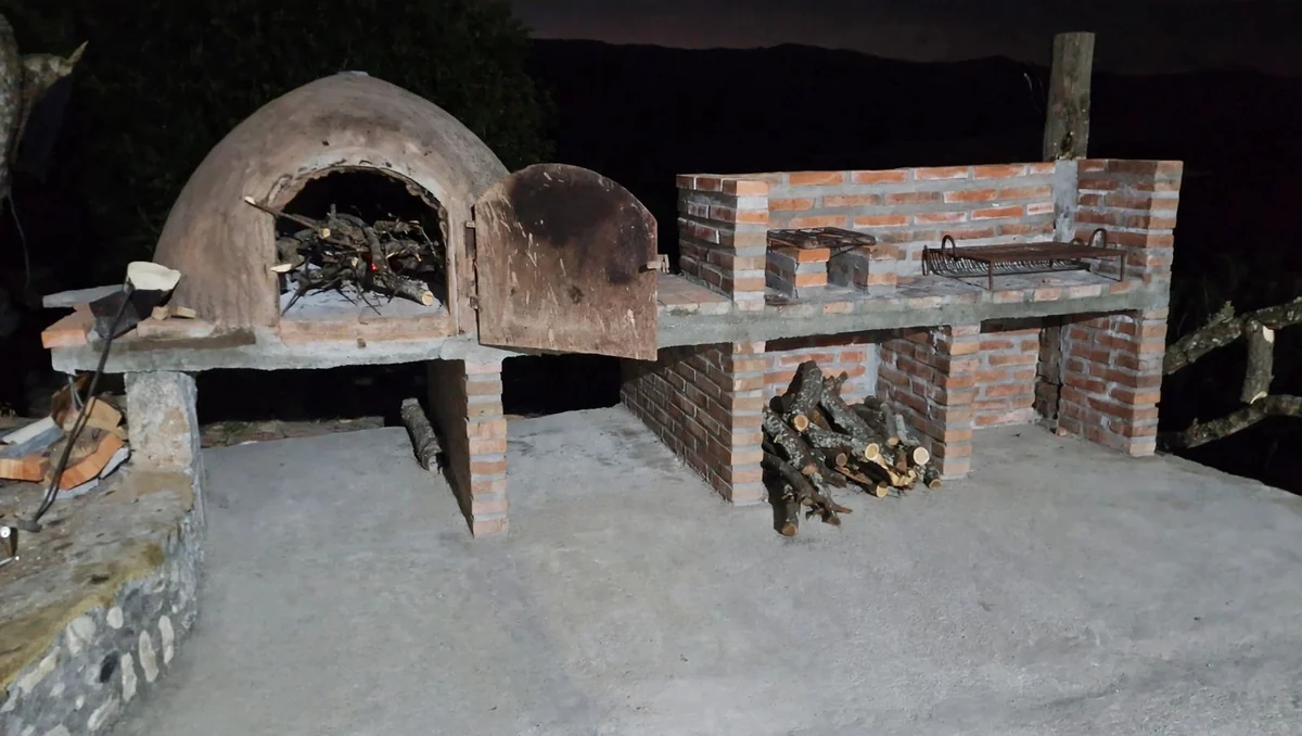 Horno de barro y parrilla de ladrillo de Rancho Quilla, la casa grande, con la leña estibada debajo
