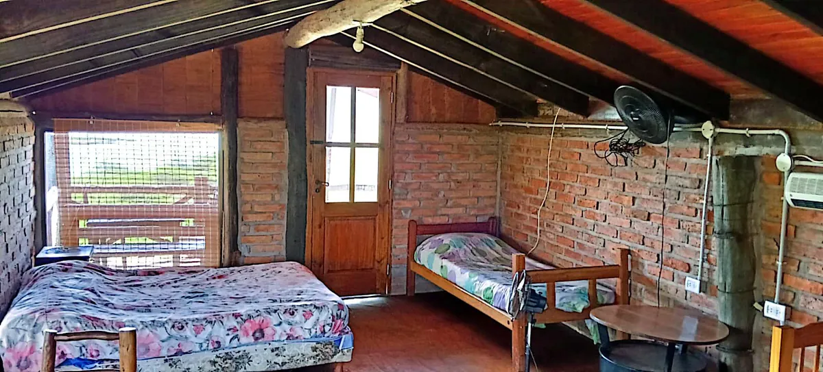 Dormitorio en la planta alta de Mate Luna, con techo de madera