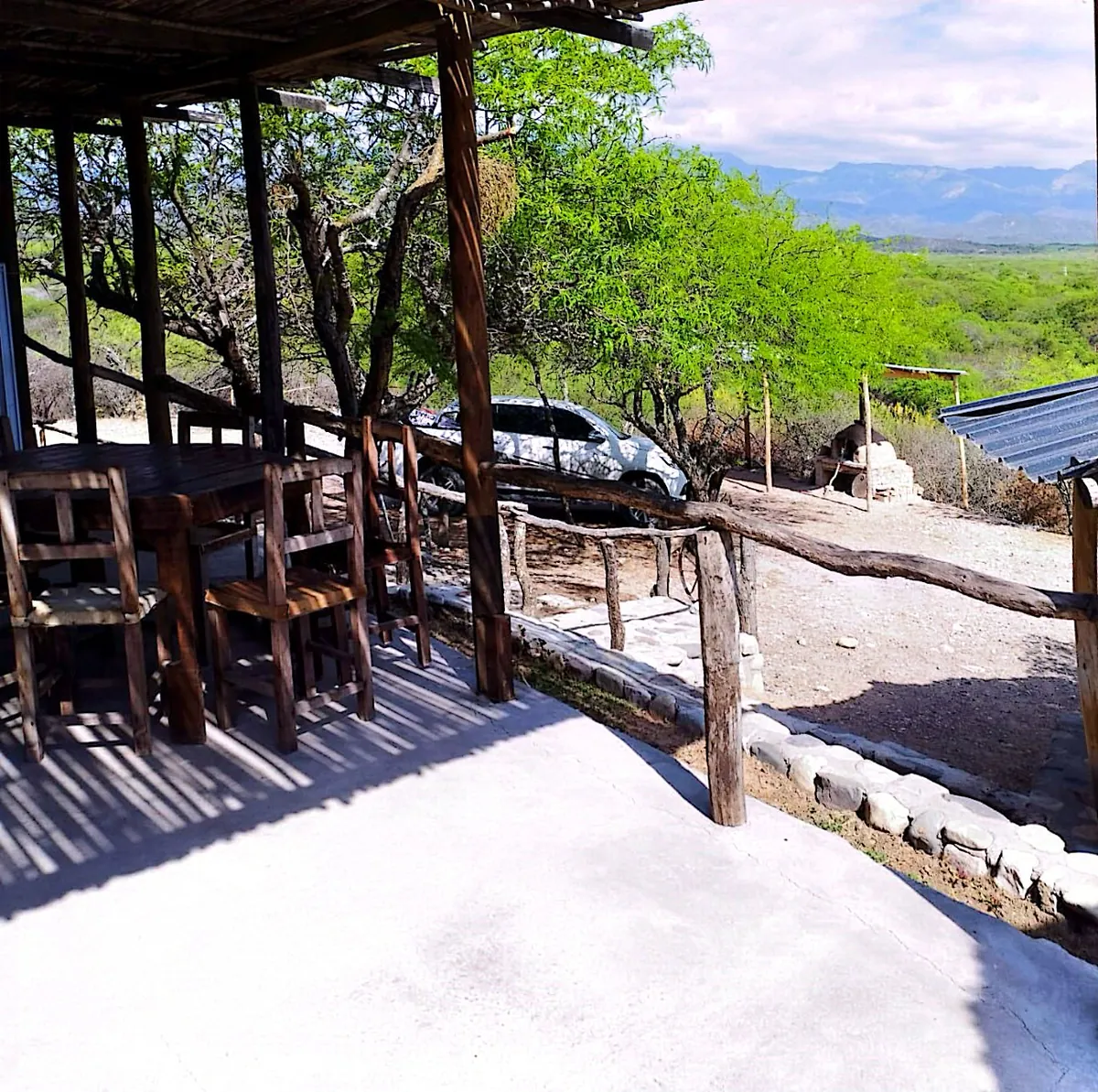 Galería de Mate Luna con sillas de madera y vista al monte