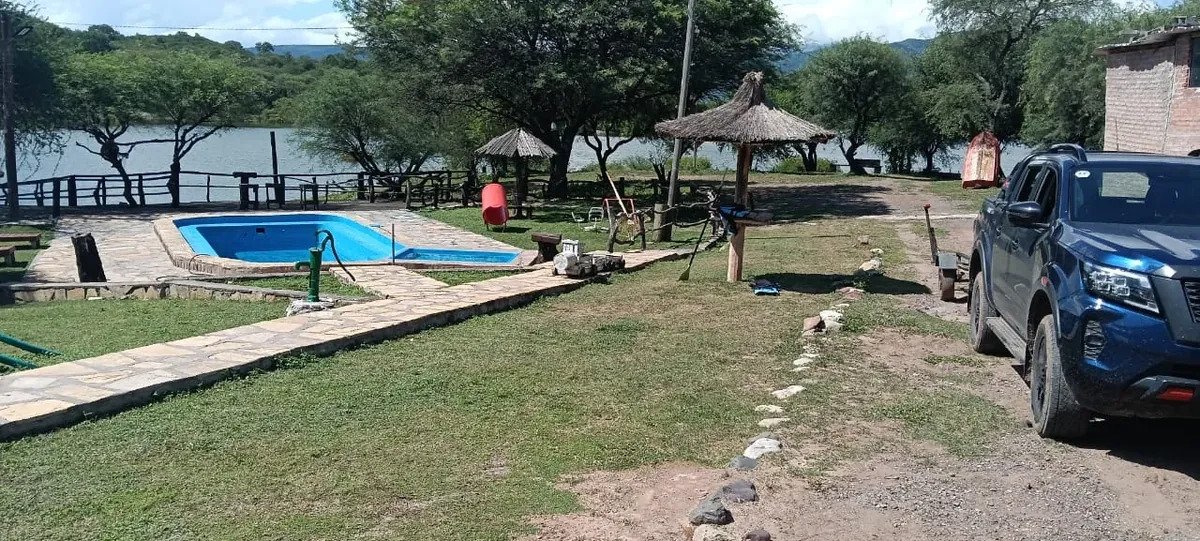 Pileta de Rancho Quilla, la casa grande con el Dique Cabra Corral detrás