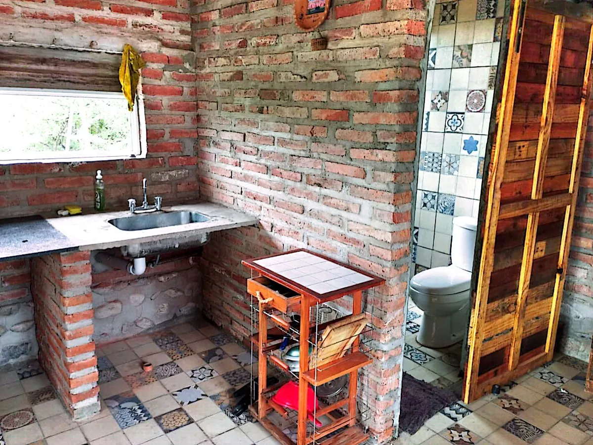 Cocina y baño de Ranchito, con puerta de tablones de madera